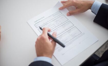 Close-up of a business professional reviewing an application form at a desk.