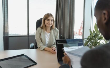 Young woman sitting confidently in a modern office for a job interview.